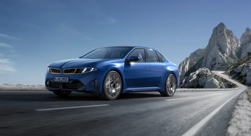 Mavi BMW i3 50 xDrive sahil yolunda önden üç çeyrek görünüm