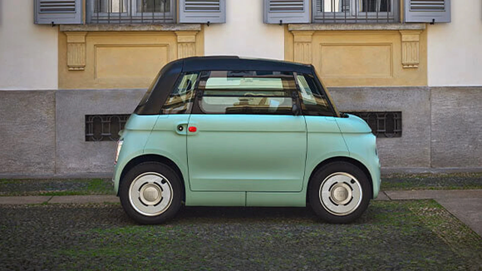 Verde Vita Fiat Topolino, şehir mimarisi önünde açık gövde yan profiliyle