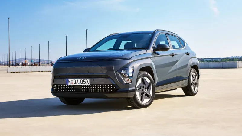 Doğal ortamda Meta Mavi Hyundai KONA Elektrik ön üç çeyrek görünümü