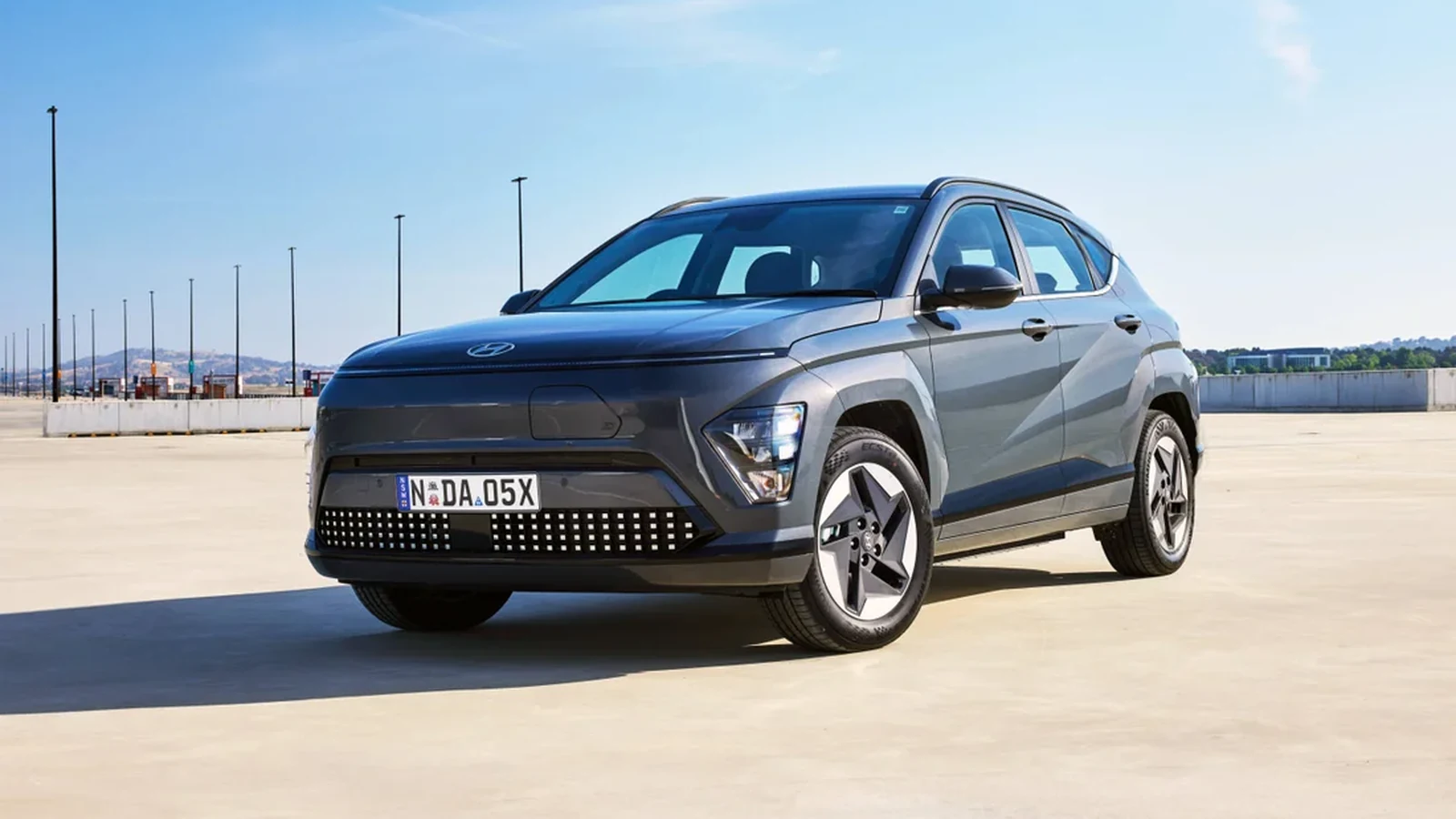 Doğal ortamda gri Hyundai KONA Elektrik ön üç çeyrek görünümü