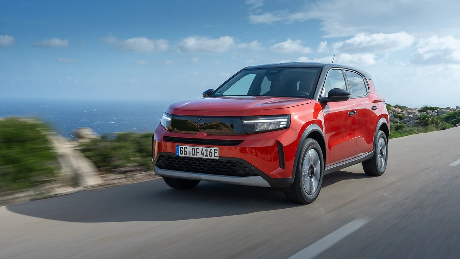 Kanyon Turuncu Opel Frontera Elektrik kıyı yolunda ön üç çeyrek görünümü