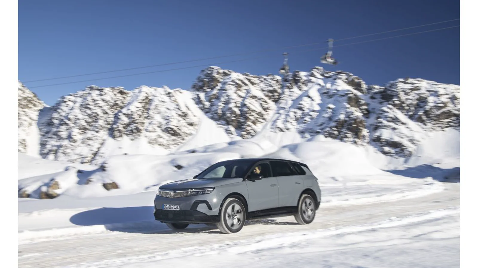 Gri Opel Grandland Elektrik AWD karlı yolda ön yan görünümü