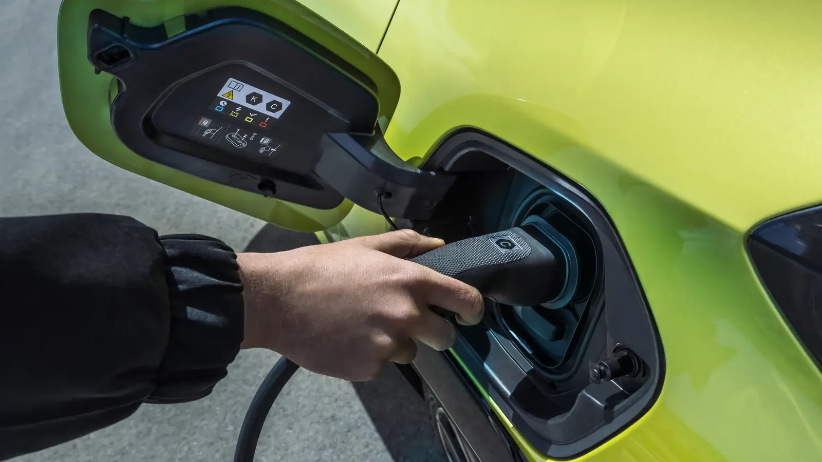 Elektrikli otomobilin şarj portuna kablo takan sürücü eli
